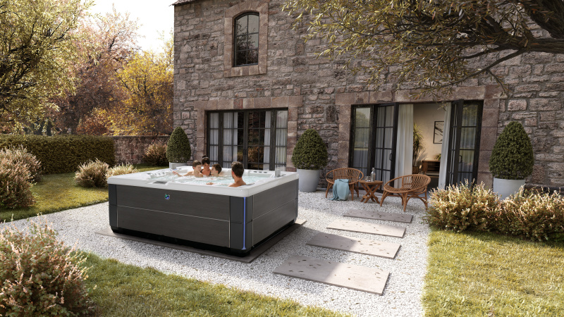 Wybór wanny spa – po czym poznasz jakościowy produkt? HotSpring_2024_Highlife_Envoy_AlpineWhite_Charcoal_Lifestyle_Fall