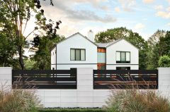 betonowe ogrodzenie firmy JONIEC® z czarnymi poziomymi panelami i eleganckim domem w tle, otoczone zielenią